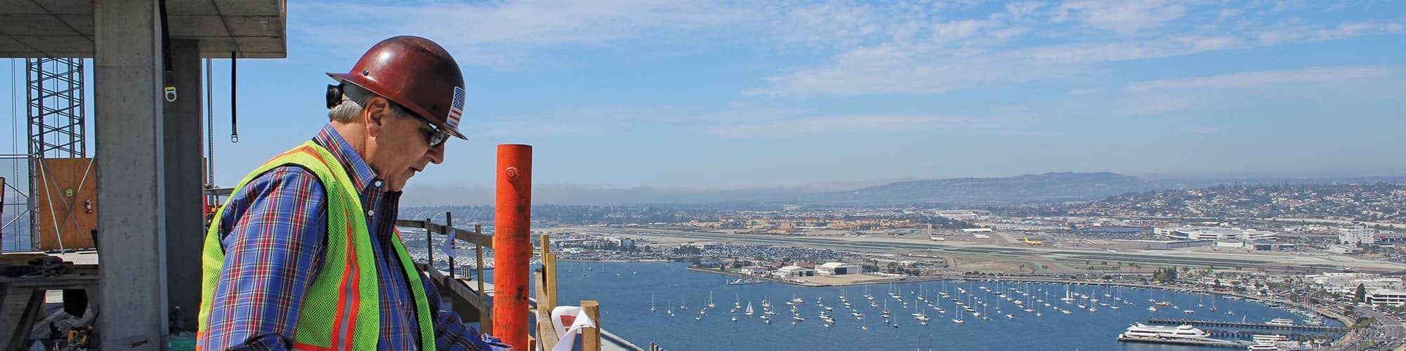 man does construction work high above the bay
