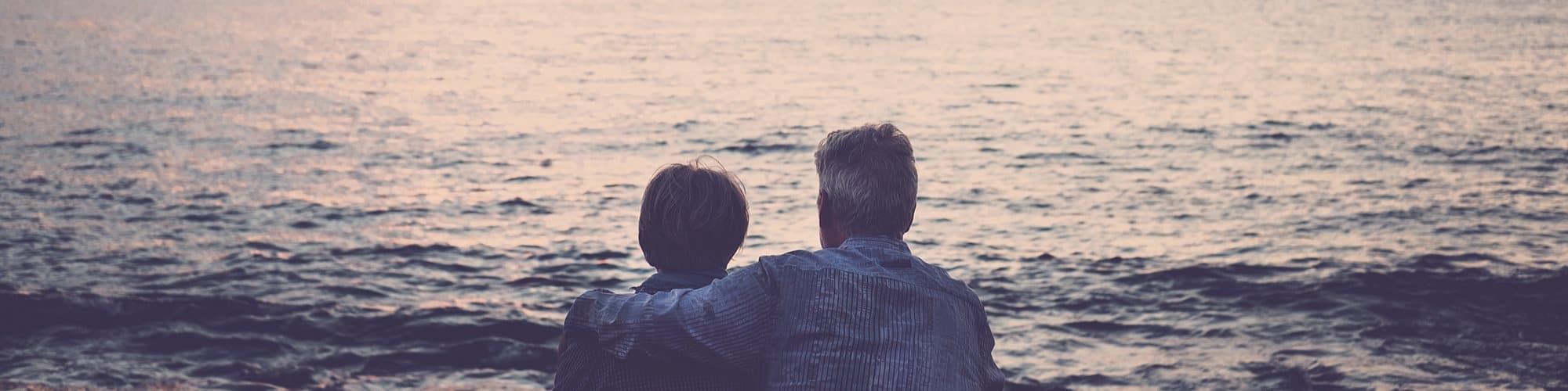 Elderly couple stares at the ocean